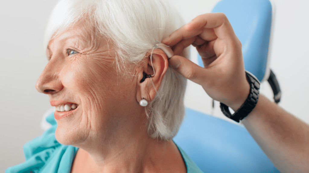 doctor helping senior dementia patient with hearing aid , close-up